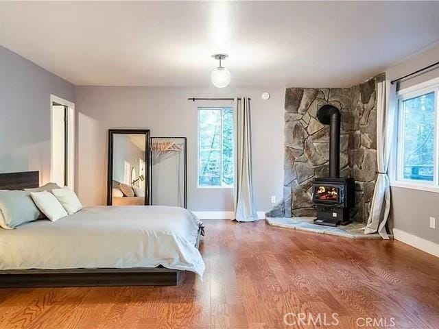 555 Dover Ct, Lake Arrowhead, CA 92352 - bedroom with wood finished floors, baseboards, multiple windows, and a wood stove