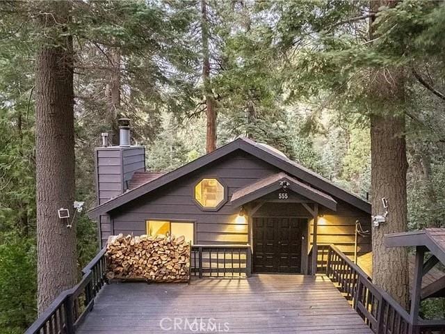 555 Dover Ct, Lake Arrowhead, CA 92352 - back of property with a chimney, a wooden deck, and concrete driveway