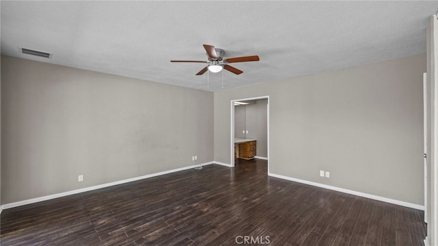 unfurnished room featuring dark wood-type flooring, a textured ceiling, and ceiling fan