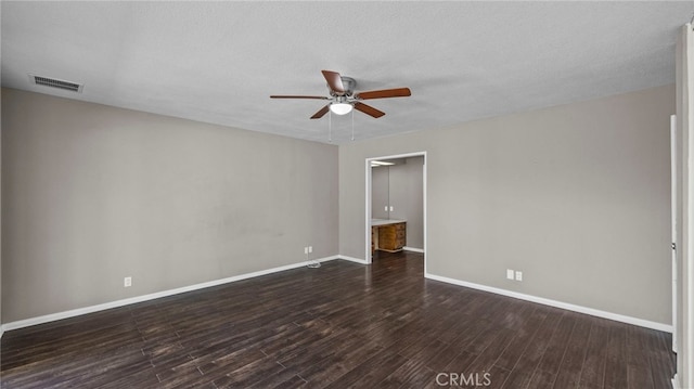 spare room with ceiling fan, dark hardwood / wood-style flooring, and a textured ceiling