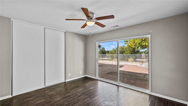 spare room featuring ceiling fan, dark hardwood / wood-style floors, and a textured ceiling