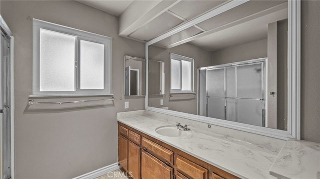 bathroom with a shower with door and vanity