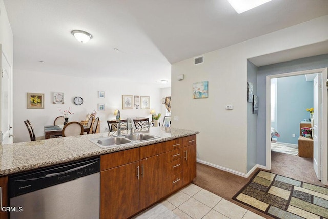 kitchen featuring sink, stainless steel dishwasher, light stone counters, and light tile patterned floors