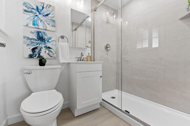 bathroom featuring hardwood / wood-style flooring, vanity, a shower with shower door, and toilet