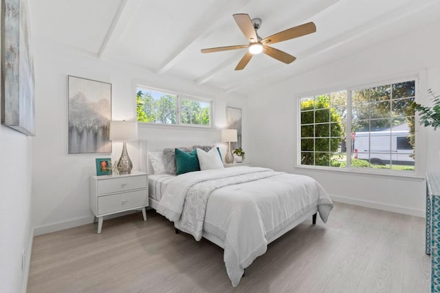 bedroom with lofted ceiling with beams, ceiling fan, and light wood-type flooring