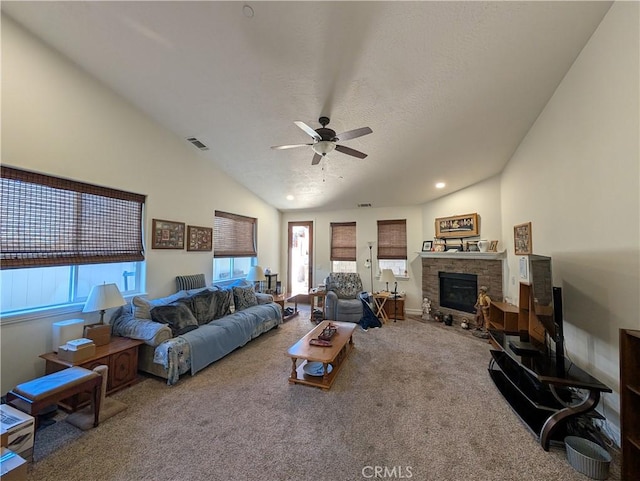 living room with ceiling fan, carpet flooring, vaulted ceiling, and a textured ceiling