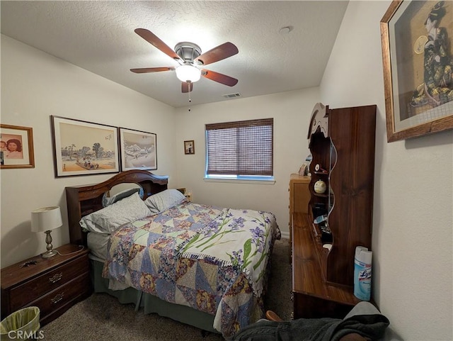 carpeted bedroom featuring a textured ceiling and ceiling fan