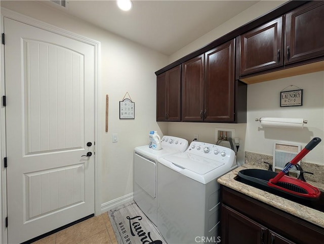 laundry room featuring sink, light tile patterned floors, washer and clothes dryer, and cabinets