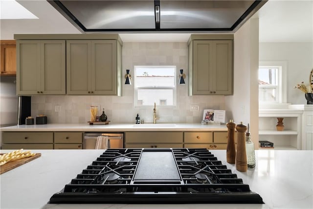 kitchen featuring sink, decorative backsplash, black gas stovetop, and stainless steel dishwasher