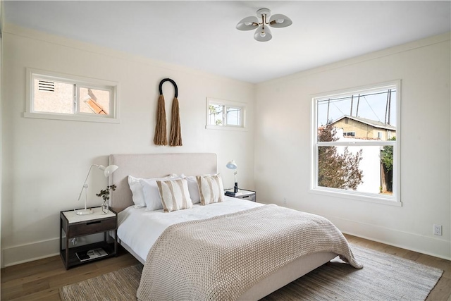 bedroom with dark hardwood / wood-style flooring