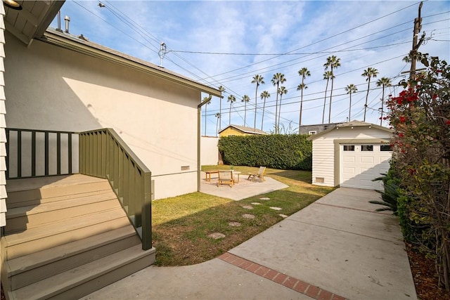 view of yard featuring a storage unit, a patio area, a fire pit, and a garage