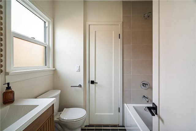 full bathroom featuring tiled shower / bath combo, vanity, and toilet