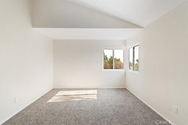 unfurnished room featuring vaulted ceiling and carpet flooring