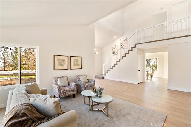 living room featuring high vaulted ceiling and light wood-type flooring