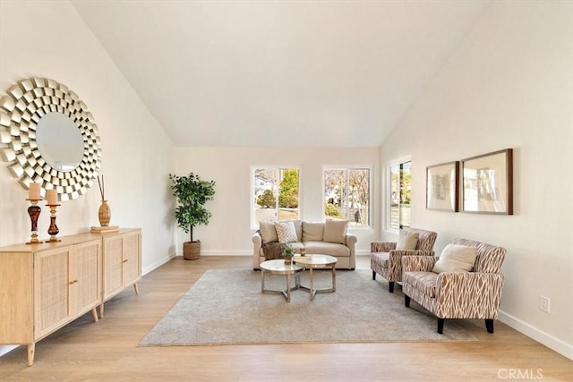 living room featuring high vaulted ceiling and light wood-type flooring