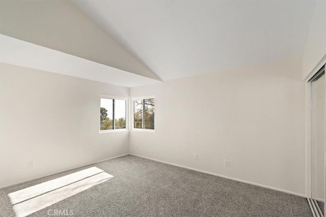 empty room with vaulted ceiling and carpet