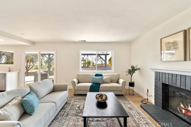 living room featuring hardwood / wood-style flooring and a brick fireplace