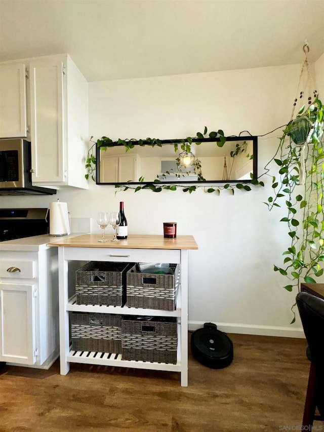 bar featuring white cabinetry and dark hardwood / wood-style floors