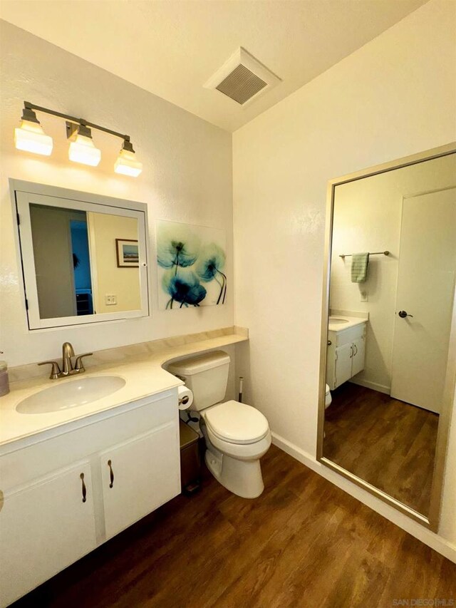 bathroom with vanity, hardwood / wood-style flooring, and toilet