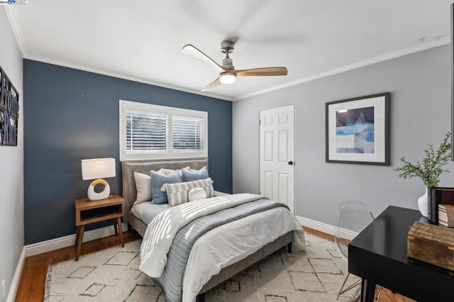 bedroom with crown molding, light wood-type flooring, and ceiling fan