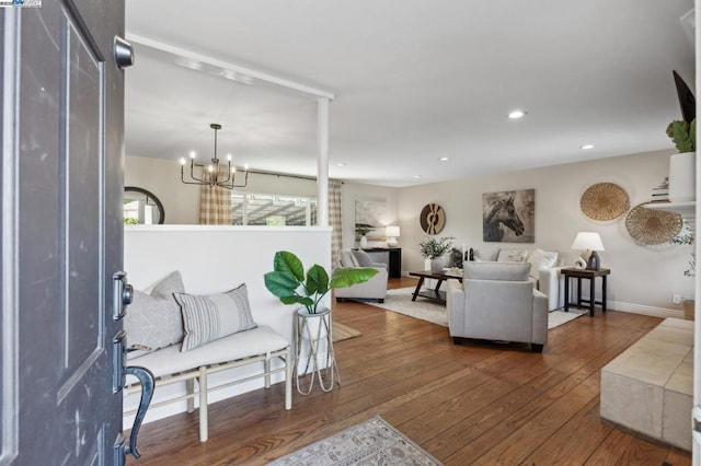 living room with dark hardwood / wood-style flooring and an inviting chandelier