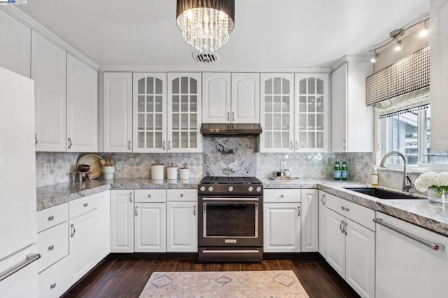 kitchen featuring gas range, sink, and white cabinets