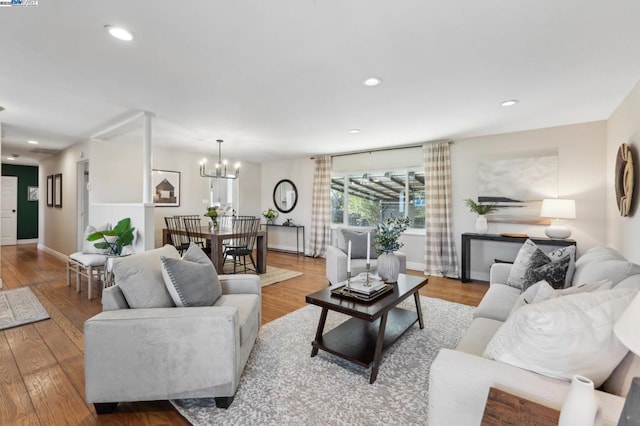 living room with an inviting chandelier and light hardwood / wood-style flooring