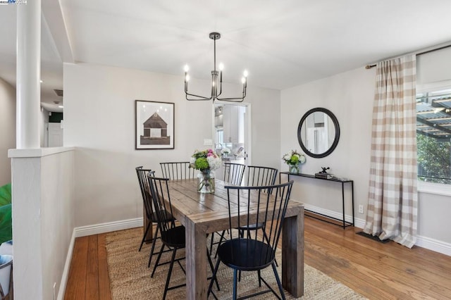 dining room with wood-type flooring and an inviting chandelier