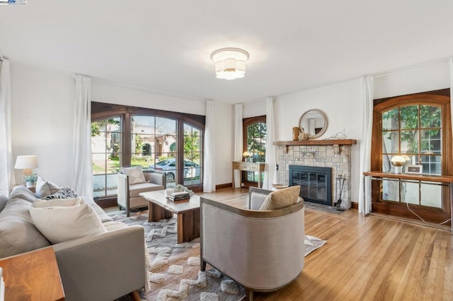 living room featuring a stone fireplace and light hardwood / wood-style floors