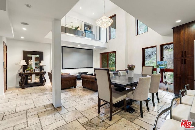 dining space with a towering ceiling and a notable chandelier