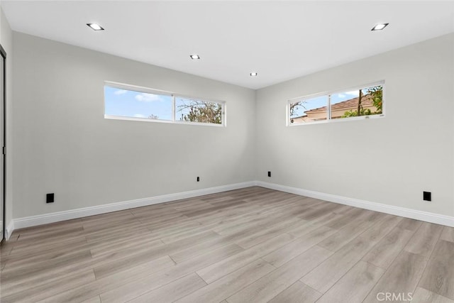 empty room featuring a wealth of natural light and light wood-type flooring