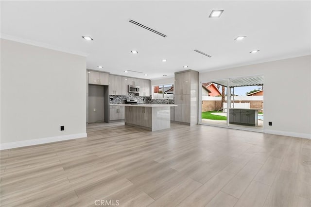 kitchen featuring ornamental molding, a center island, gray cabinetry, and backsplash