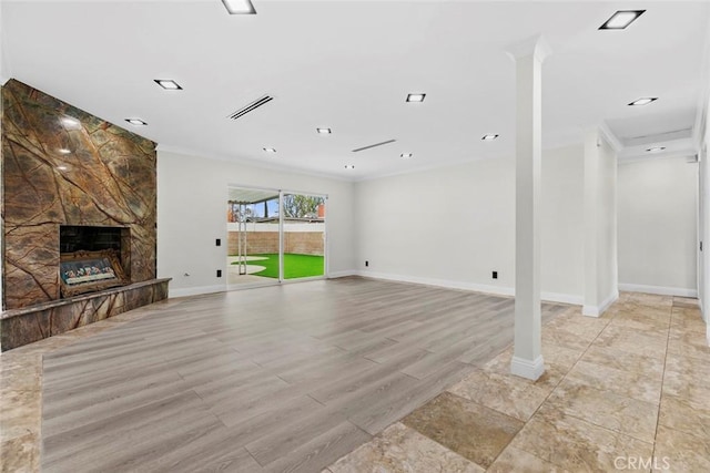 unfurnished living room with crown molding, a large fireplace, and light hardwood / wood-style floors