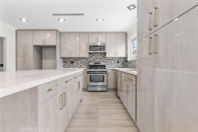 kitchen with crown molding, light stone countertops, decorative backsplash, and appliances with stainless steel finishes