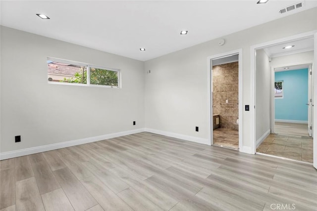 unfurnished bedroom featuring connected bathroom and light hardwood / wood-style flooring