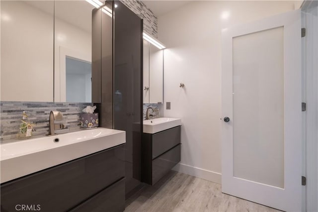 bathroom with vanity, hardwood / wood-style floors, and decorative backsplash