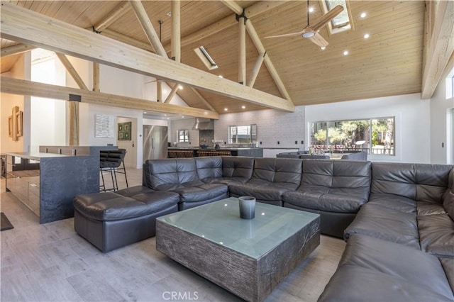 living room with beamed ceiling, high vaulted ceiling, wood ceiling, and a skylight