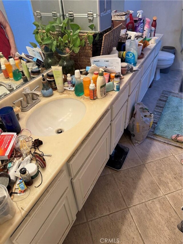 bathroom featuring toilet, tile patterned flooring, and sink