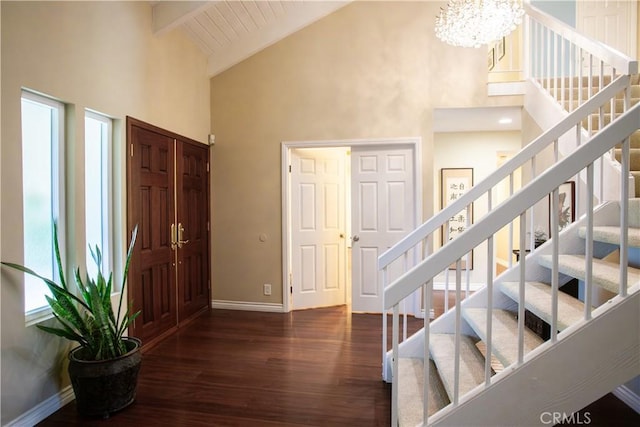 foyer entrance with an inviting chandelier, high vaulted ceiling, dark hardwood / wood-style floors, and beamed ceiling