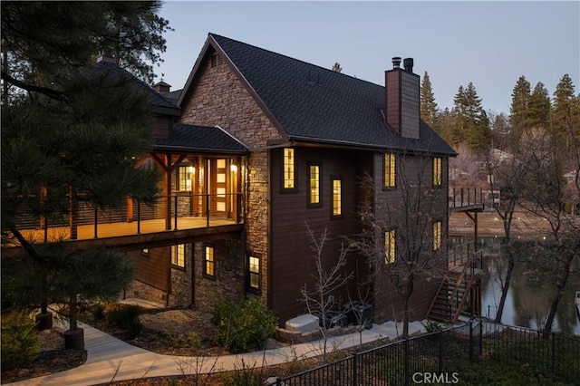 property exterior at dusk featuring a balcony