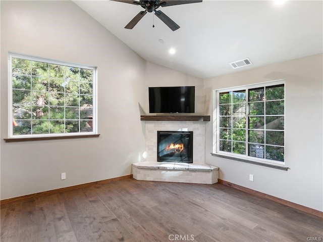 unfurnished living room featuring hardwood / wood-style flooring, ceiling fan, lofted ceiling, and a fireplace