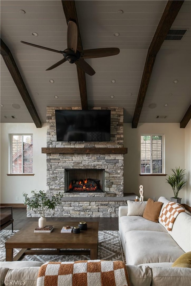 living room featuring beamed ceiling, ceiling fan, a fireplace, and hardwood / wood-style floors