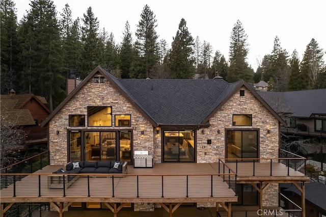 rear view of property with an outdoor living space and a wooden deck