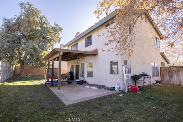 back of property with a patio and a yard