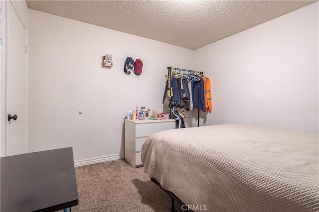 bedroom featuring light colored carpet and a textured ceiling