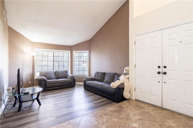 living room featuring light tile patterned flooring and vaulted ceiling