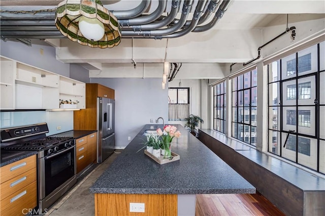 kitchen featuring appliances with stainless steel finishes, sink, and an island with sink