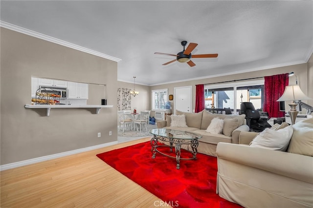 living room with crown molding, ceiling fan with notable chandelier, and light wood-type flooring