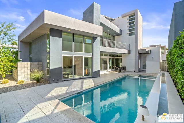 rear view of house featuring a fenced in pool and a patio area