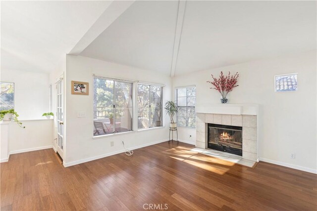 unfurnished living room with lofted ceiling, a fireplace, and hardwood / wood-style floors